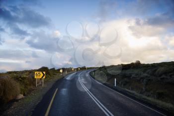 Bend on the Great Ocean Road of Australia with a speed limit of 65 kph. Horizontal shot.