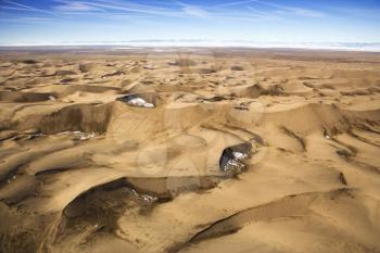 Aerial view of a desert landscape with sand dunes. Horizontal shot.