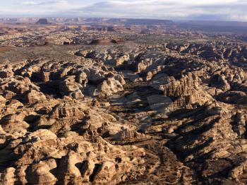 Rock formations caused by wind and water in the desert with a mesa in the background. Horizontal shot.