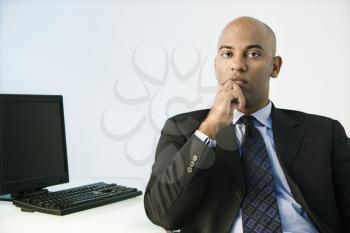 African American businessman sitting at office desk.