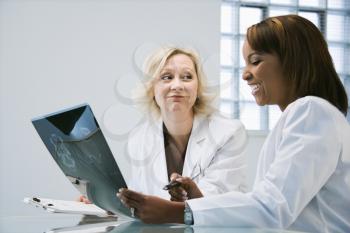 Women doctors looking at patient x ray films.