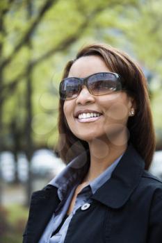 Portrait of African American woman wearing sunglasses and smiling.