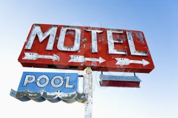 Old weathered retro neon motel sign advertising pool and vacancy. Horizontal shot.
