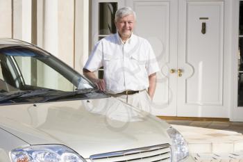 Royalty Free Photo of a Senior Man Outside His Home Beside a Car
