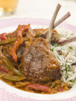 Royalty Free Photo of a Lamb Cutlet Jalfrezi With Fragrant Pilau and Indian Beer