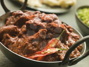Royalty Free Photo of a Meat Phall in Karahi With Naan and Green Chilli Curry