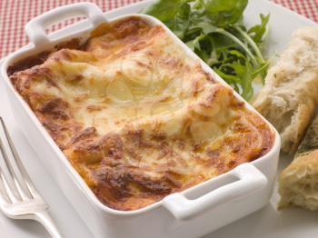 Royalty Free Photo of a Pan of Lasagna With Bread and Salad