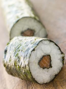 Royalty Free Photo of a Roll of Salmon Sushi on a Board
