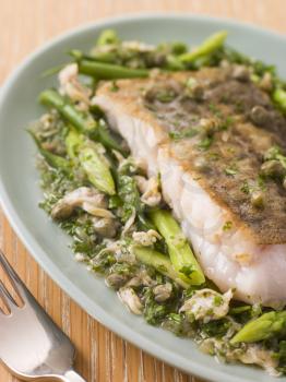 Royalty Free Photo of Fillet of Hake With Cockles Green Vegetables and Salsa Verde