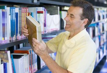 Royalty Free Photo of a Man Choosing a Book in a Library