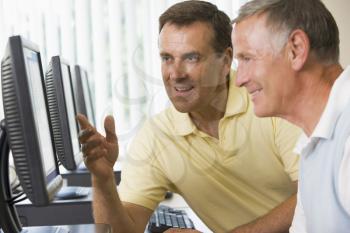 Royalty Free Photo of Two Men Talking While Working on Computers