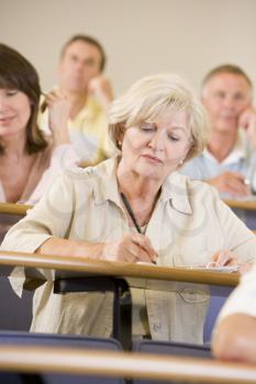 Royalty Free Photo of an Older Woman in a Classroom Taking Notes
