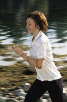 Royalty Free Photo of a Woman Running By a Stream