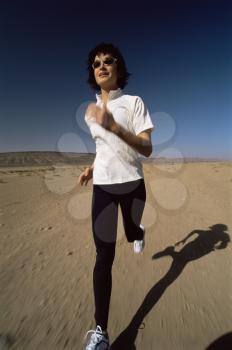 Royalty Free Photo of a Woman Running on Sand