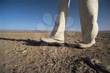 Royalty Free Photo of a Man's Legs Walking in a Desert