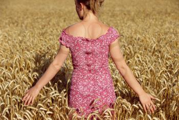 Royalty Free Photo of a Woman Standing in a Field of Wheat