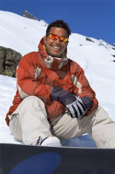 Royalty Free Photo of a Snowboarder Sitting and Smiling