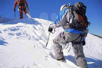 Royalty Free Photo of Two Mountain Climbers Walking in Snow