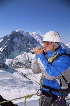 Royalty Free Photo of a Mountain Climber Blowing on His Hands