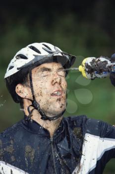 Royalty Free Photo of a Cyclist Splashing Water on His Face