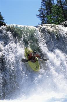 Royalty Free Photo of a Kayaker Going Over Rapids