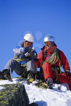 Royalty Free Photo of Two Mountain Climbers Drinking From a Thermos