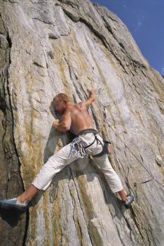 Royalty Free Photo of a Man Climbing a Rock Face