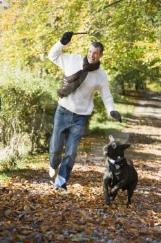 Royalty Free Photo of a Man and a Dog Running in the Park