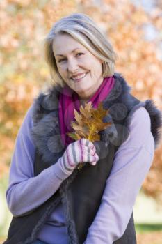 Royalty Free Photo of a Woman Outside Holding Leaves