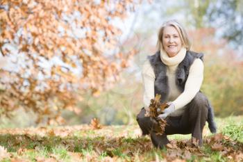 Royalty Free Photo of a Woman Playing in the Leaves