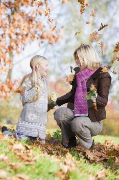 Royalty Free Photo of a Woman and Child Playing in the Leaves