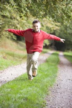 Royalty Free Photo of a Young Boy Running on a Path