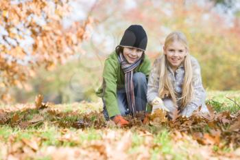 Royalty Free Photo of Two Children Playing in the Leaves
