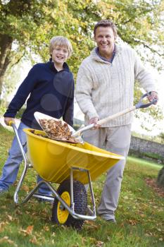 Royalty Free Photo of a Man Raking Leaves With a Boy