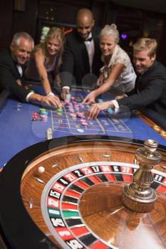 Royalty Free Photo of a Group of People Around a Roulette Table