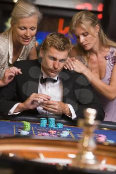 Royalty Free Photo of a Man and Two Women in a Casino