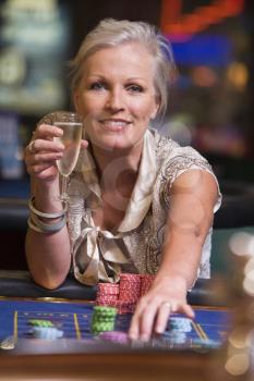 Woman in casino playing roulette and smiling (selective focus)