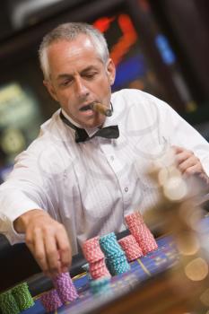 Royalty Free Photo of a Man With a Cigar at a Roulette Table