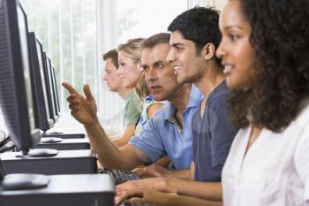 Royalty Free Photo of a Computer Class With the Teacher Helping a Student