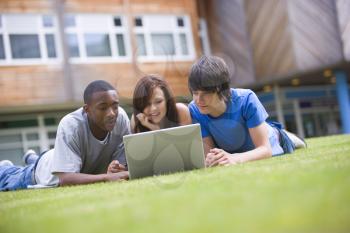 Royalty Free Photo of Three Students Outside With a Laptop