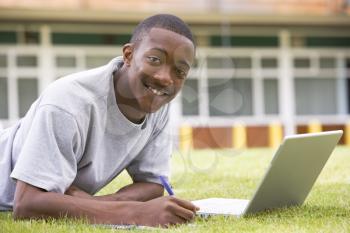 Royalty Free Photo of a Student on the Lawn With a Laptop