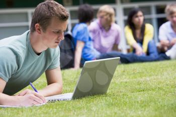Royalty Free Photo of Students Outside With One Taking Notes From a Laptop
