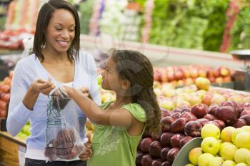 Royalty Free Photo of a Mother and Daughter Shopping for Apples