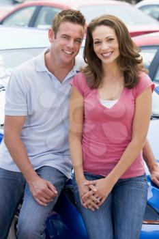 Royalty Free Photo of a Couple Leaning on a Car