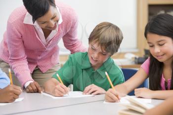 Royalty Free Photo of a Teacher Helping Students With Writing