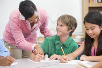 Royalty Free Photo of a Teacher Helping Students With Writing