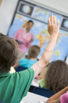 Royalty Free Photo of a Teacher and Class With a Child Raising His Hand