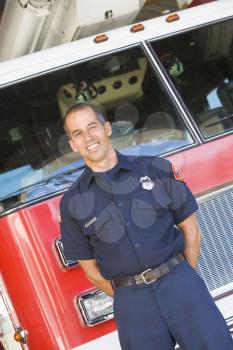 Royalty Free Photo of a Firefighter in Front of a Firetruck
