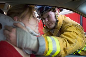 Royalty Free Photo of a Firefighter Putting a Neck Brace on a Woman