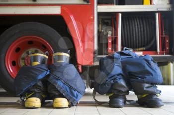 Royalty Free Photo of Firefighting Boots and Pants by a Truck